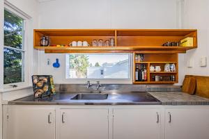 a kitchen with a sink and a window at Ohakune's Yellow Door in Ohakune +14 photos
