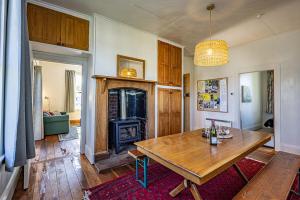 a living room with a wooden table and a fireplace at Ohakune's Yellow Door in Ohakune