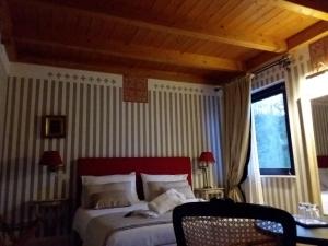 塞尼加利亞的住宿－Country House Martines Club Resort & Mandalay SPA，一间卧室配有一张带红色床头板的床和窗户