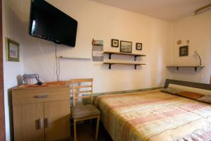a bedroom with a bed and a tv on the wall at Apartments Petrič in Koper