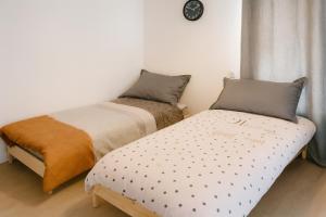 a bedroom with two beds and a clock on the wall at Appartement modulable in Lannemezan