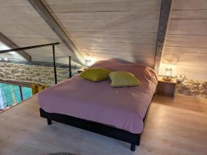 a bedroom with a bed with purple sheets and pillows at Gîte du Portz in Ploërdut