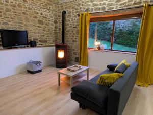 a living room with a couch and a tv at Gîte du Portz in Ploërdut