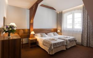 a bedroom with a large bed and a large window at Hotel Wit Stwosz in Krakow