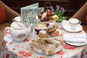 un set de té con pastas y sándwiches en una mesa en Macdonald New Blossoms Hotel, en Chester