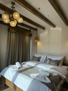 a bedroom with a large bed with white sheets at Hotel Restorant Unaza in Voskopojë