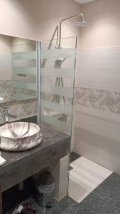 a bathroom with a glass shower and a sink at فندق بفنPuffin hotel in Qaryat al ‘Ulyā +23 photos