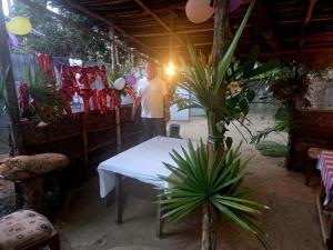 a man standing next to a table in a room with plants at Chapel Home Stay in Ahungalla