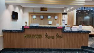 a welcome sign at a welcome desk in a hotel lobby at فندق بفنPuffin hotel in Qaryat al ‘Ulyā