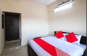 a bedroom with a red and white bed with red pillows at SLP Residency in Mysore