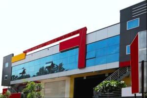 an office building with a red and yellow sign on it at SLP Residency in Mysore