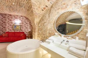 a bathroom with a white tub and a red couch at Logis Hotel Saint-Martin in Colmar +78 photos