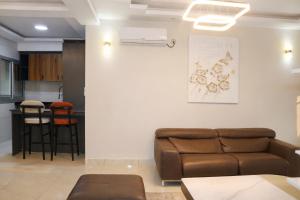 a living room with a couch and a kitchen at Empire Luxury Hotel in Yaoundé