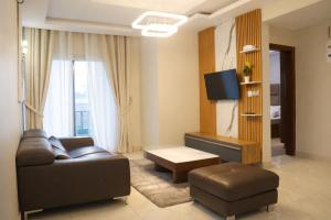 a living room with a couch and a tv at Empire Luxury Hotel in Yaoundé