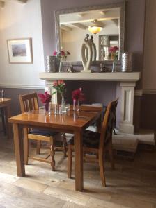 a dining room table with chairs and a mirror at Three-Cranes in Turvey