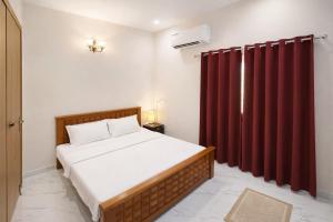 a bedroom with a bed and a red curtain at Sri Apartment Homestay 2BHK Pondicherry A1 in Pondicherry