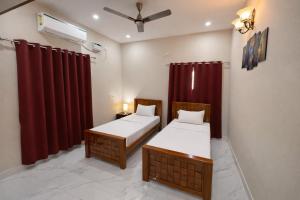 two beds in a room with red curtains at Sri Apartment Homestay 2BHK Pondicherry A1 in Pondicherry