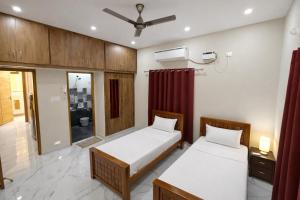 a bedroom with two beds and a ceiling fan at Sri Apartment Homestay 2BHK Pondicherry A1 in Pondicherry