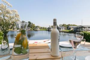 een tafel met een fles wijn en glazen bij Vakantie in Terherne in Terherne