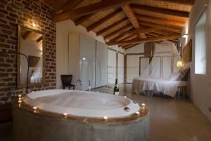 eine Badewanne in einem Zimmer mit einem Schlafzimmer in der Unterkunft Il Riposo in San Damiano dʼAsti