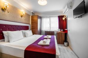 a hotel room with a bed with two towels on it at Cihangir Palace Hotel in Istanbul