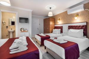 a hotel room with two beds with towels on them at Cihangir Palace Hotel in Istanbul