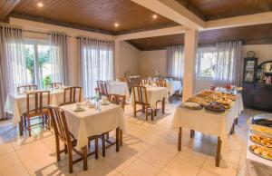 a dining room with tables and chairs with food on them at Pousada do Tirol in Gramado