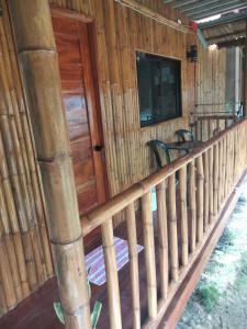 a front porch of a log cabin with a wooden door at The Garden Tropical Cabins in Basdiot