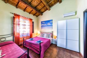 a bedroom with two beds and a white refrigerator at Mari e Luci in Nurachi