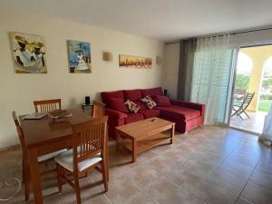 a living room with a red couch and a table at Can Chus Cala Anguila in Cala Mendia