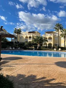 a resort with a swimming pool and palm trees at Can Chus Cala Anguila in Cala Mendia