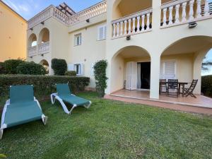 a yard with two chairs and a house at Can Chus Cala Anguila in Cala Mendia