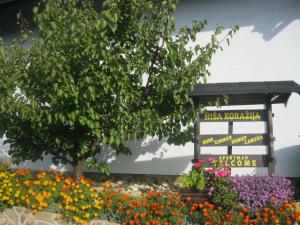 un cartel en un jardín con flores en Hiša Koražija en Rogaška Slatina