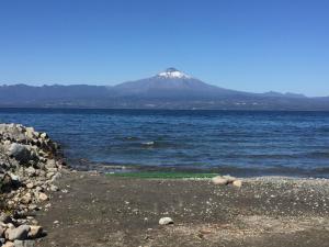 una montaña en medio de un gran cuerpo de agua en Cabaña Lago Villarrica ideal 2 familias, en Villarrica