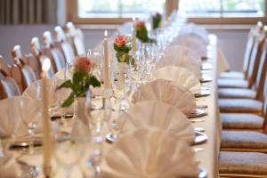 a long table with glasses and roses on it at Wander- & Wellnesshotel Nägele in Höchenschwand +37 photos