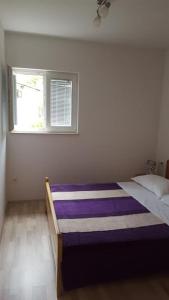 a bed in a room with a window at Apartment Marta in Podgora