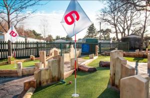 a miniature golf course in a park with flags at Quince on Oakdene country Park in Ringwood