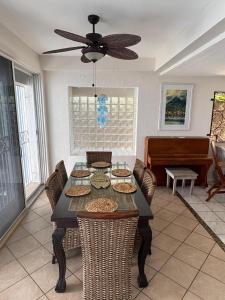 a dining room with a table with chairs and a piano at Villa Paradiso in Basseterre
