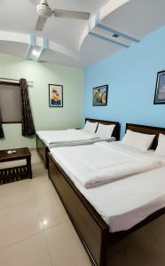 two beds sitting in a room with at Hotel Aryaman in Haridwār
