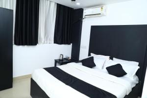 a black and white bedroom with a large bed at Erica Hotel International in Perintalmanna
