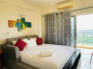 a bedroom with a bed with red pillows and a window at Atrium - ICONIC APARTMENT in Sri Jayewardenepura Kotte +60 photos