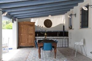 ラグーザにあるVilla Tipica Casa Tuaのキッチン(木製テーブル、青い椅子付)