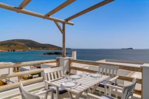a table and chairs on a balcony overlooking the ocean at Endless Blue from Syros - Fabrika House 1 & 2 in Vári