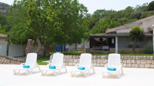 ラグーザにあるVilla Tipica Casa Tuaの家の横に四脚の白い椅子