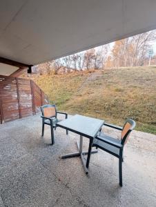 a picnic table and two chairs on a patio at Centre Thermal studio NORD S4003 in Ovronnaz