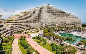 a large building next to a marina with boats at STUDIO-PORT-MARINA, Parking privé, climatisé au "DUCAL" in Villeneuve-Loubet