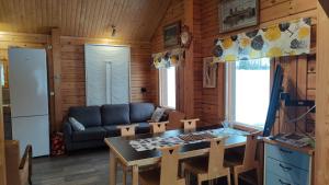 a kitchen and living room with a table and a couch at Kaijonselän mökit Kaita in Kaitainen +12 photos
