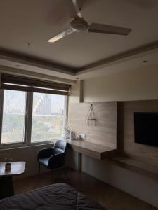 a bedroom with a desk and a chair and a window at Luna Stays in Greater Noida