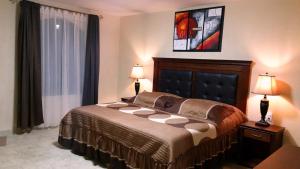 ein Schlafzimmer mit einem Bett mit zwei Lampen und einem Fenster in der Unterkunft Hotel Villa Bernal in Bernal