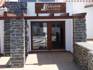 a entrance to a building with a glass door at Falésias da Arrifana in Praia da Arrifana